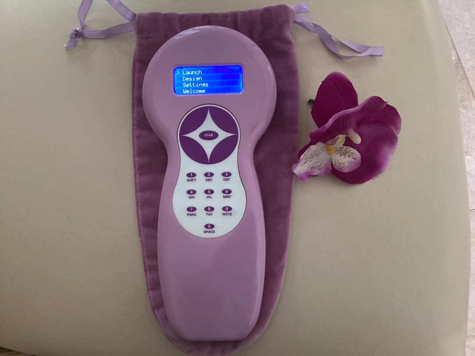 Quantumwave cold soft laser device — portable handheld unit with display screen and velvet pouch
