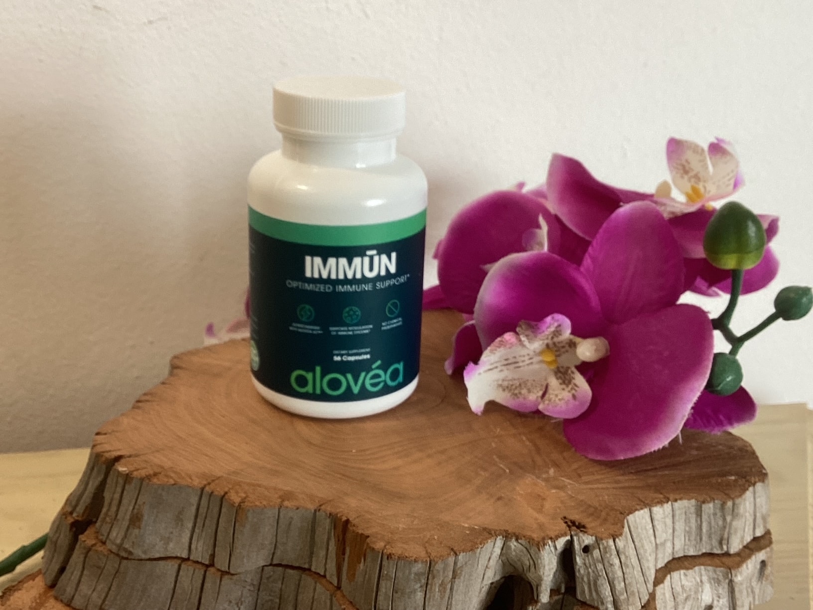 Alovea Immun supplement bottle with orchid flowers